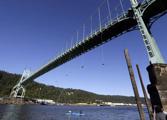 Activists hang from the St. Johns bridge in Portland, Ore., Wednesday, July 29, 2015, to protest the departure of Royal Dutch Shell PLC icebreaker Fennica, which is in Portland for repairs. (Photo by Don Ryan/AP Photo)
