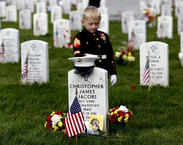 Christian Jacobs, 5, of Hertford, N.C., dressed as a Marine, pauses at his father's gravestone on Memorial Day at Arlington National Cemetery in Arlington, Va., Monday, May 30, 2016. Christian's father Marine Sgt. Christopher James Jacobs died in a training accident in 2011. (Photo by Carolyn Kaster/AP Photo)