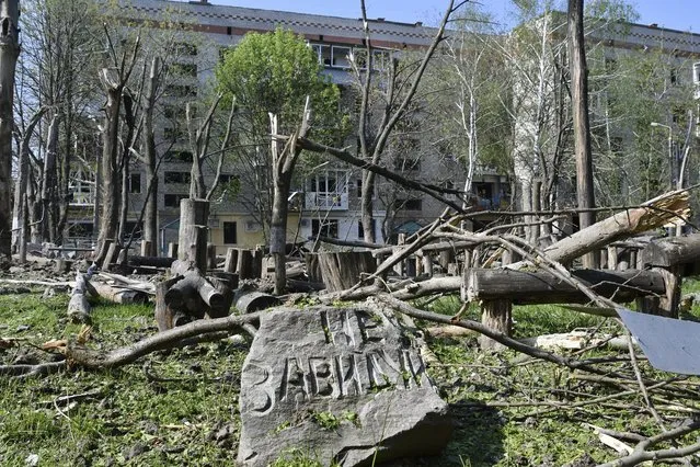 A stone with a sign reads “Don't be jealous” is seen in a yard of an apartment building destroyed by night shelling in Kramatorsk, Ukraine, Thursday, May 5, 2022. (Photo by Andriy Andriyenko/AP Photo)