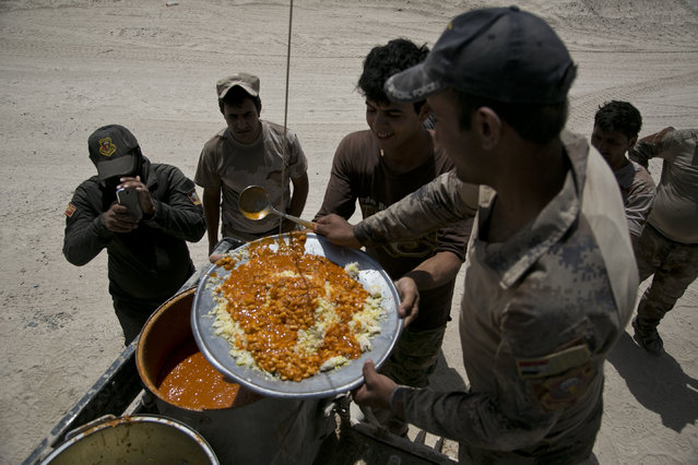 Iraqi counterterrorism forces take their lunch on their front line position during an operation to oust Islamic State militants from Fallujah, Iraq, Tuesday, June 7, 2016. It's the first fasting day of the Muslim holy month of Ramadan – the country's most influential Shiite cleric said Monday that Iraqi fighters could obtain from the Ramadan fast if they thought it impaired their ability on the battlefield. (Photo by Maya Alleruzzo/AP Photo)