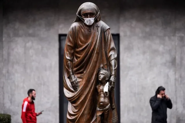 A face mask is placed on the statue of Saint Teresa in Pristina on December 19, 2019. Pristina and many other cities across Kosovo experienced high levels of visible air pollution. Over the past months Pristina was listed as one of the cities suffering from the worst air quality in the world. (Photo by Armend Nimani/AFP Photo)