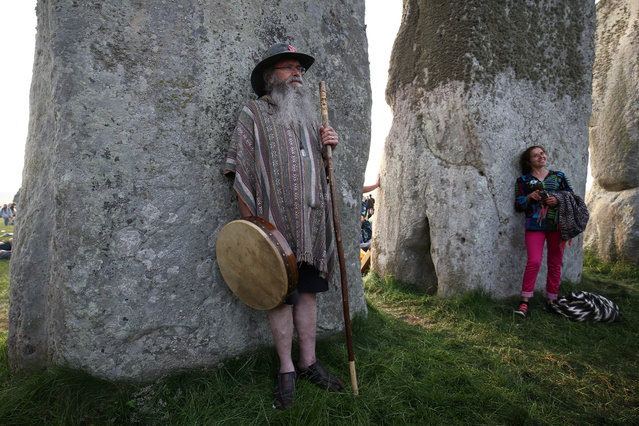 People rest against the stones of the Stonehenge monument at dawn on the summer solstice near Amesbury, Britain on June 21, 2017. (Photo by Neil Hall/Reuters)