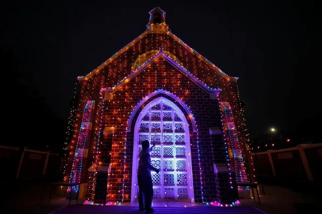 A man installs decorative lights on a church ahead of Christmas celebrations in Ahmedabad, India, December 23, 2019. (Photo by Amit Dave/Reuters)