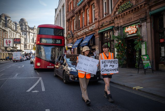 Just Stop Oil protesters slow-walk along Shaftesbury Avenue on June 15, 2023 in London, England. Protest group Just Stop Oil is campaigning to persuade the British government to commit to halting new fossil fuel licensing and production by holding Go Slow Walking protests in major cities across the UK. The Government is introducing new legislation by the end of June that will allow the police to intervene to prevent this form of protest. (Photo by Carl Court/Getty Images)