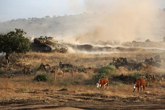 Israeli soldiers maneuver and fire a tank as they take part in a military exercise which includes infantry, tanks and artillery units in the army training area at the northern part of the Israeli-annexed Golan Heights near the border with Syria on June 23, 2016. (Photo by Menahem Kahana/AFP Photo)