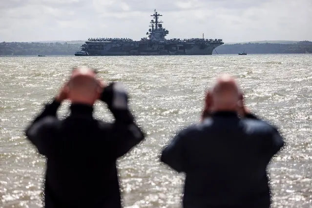 Two men look through binoculars at US Navy Nimitz-class aircraft carrier USS George H.W. Bush anchored off the coast on July 27, 2017 in Portsmouth, England. The 100,000 ton ship dropped anchor in the Solent this morning ahead of Exercise Saxon Warrior 2017, a training exercise between the UK and USA. (Photo by Jack Taylor/Getty Images)