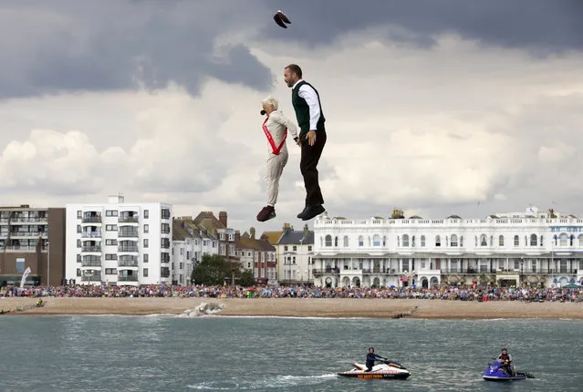 Competitors in fancy dress jump off Worthing Pier in West Sussex, Southern England on August 16, 2015, during the annual international birdman competition, a flight contest for human-powered flying machines held each summer. (Photo by Justin Tallis/AFP Photo)