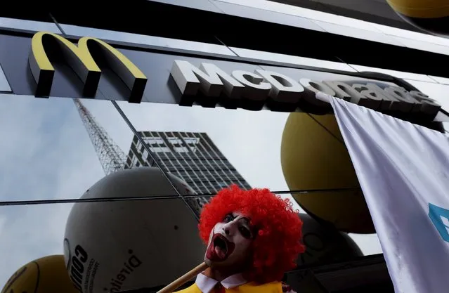 A man dressed as “Ronald McDonald”, the McDonald's company mascot, takes part in a protest against labor abuses and poor working conditions, in front of a McDonald's restaurant at Paulista avenue, in Sao Paulo, August 18, 2015. (Photo by Nacho Doce/Reuters)