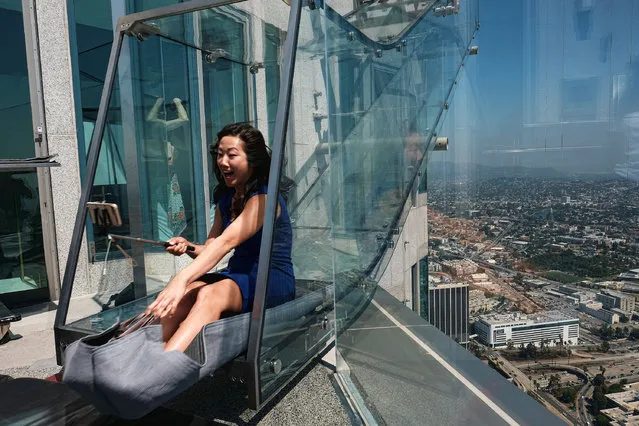 Jo Kqon, a reporter with KFI radio Los Angeles, takes a selfie as she rides down a glass slide during a media preview at the U.S. Bank Tower building in downtown Los Angeles on Thursday, June 23, 2016. Starting this weekend, thrill-seekers can begin taking the Skyslide, a 1,000 feet high slide perched outside of the tallest skyscraper west of the Mississippi. (Photo by Richard Vogel/AP Photo)