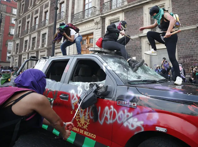 Demonstrators attack a vehicle belonging to the fire department during an International Women's Day march in Mexico City's main square, the Zocalo, Sunday, March 8, 2020. Protests against gender violence in Mexico have intensified in recent years amid an increase in killings of women and girls. (Photo by Rebecca Blackwell/AP Photo)