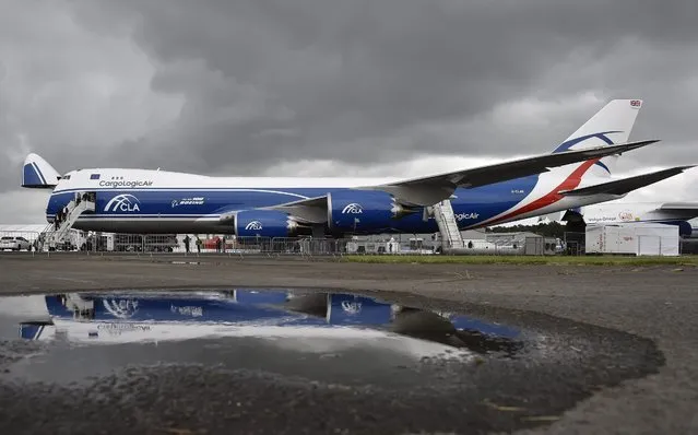 A Boeing CargoLogicAir airplane is reflected in a puddle at the Farnborough International Airshow in Farnborough, Britain, 12 July 2016. (Photo by Hannah Mckay/EPA)
