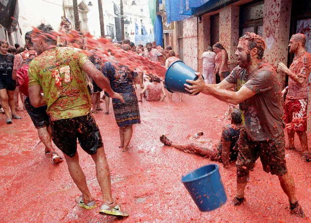 Revellers play with tomato pulp during the annual Tomatina festival in Bunol near Valencia, Spain, August 30, 2017. (Photo by Heino Kalis/Reuters)