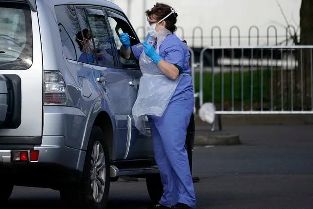 A member of the public is swabbed at a drive through Coronavirus testing site, set up in a car park, on March 12, 2020 in Wolverhampton, England. The National Health Service facility has been set up in a car park to allow people with NHS referrals to be swabbed for Covid-19. (Photo by Christopher Furlong/Getty Images)