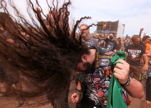 A festivalgoer does a “head banging” during the Wacken Open Air 2022 heavy metal festival in Wacken, Germany August 4, 2022. (Photo by Thilo Schmuelgen/Reuters)