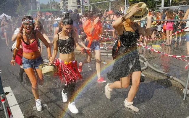 Revellers refresh under a public shower during the 24th Street Parade dance music event in Zurich, August 29, 2015. (Photo by Arnd Wiegmann/Reuters)