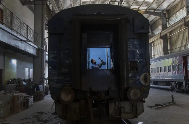 An Indian railway employee works to convert a train coach into an isolation ward for the fight against the new coronavirus in Gauhati, India, Sunday, March 29, 2020. (Photo by Anupam Nath/AP Photo)