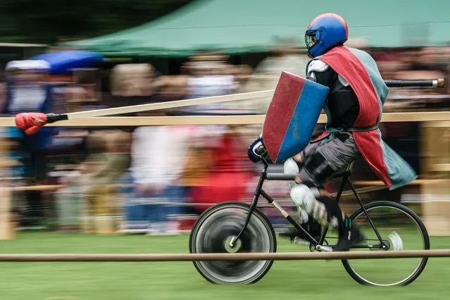 A participant rides on a bike during the so called Berlin Pedal Battle games (Baerlin Pedael Baettle), knights games on bicycles, in Berlin, Germany, 20 August 2022. During the games, cyclists in knight’s armours battle in a jousting competition, a martial game originally practiced by medieval knights on horses, fighting with lances. The idea was born by a group of bike enthusiastic couriers from Berlin in the year 2012. (Photo by Clemens Bilan/EPA/EFE)