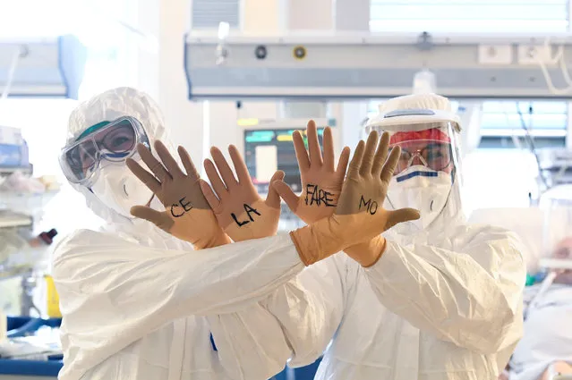 Medical staff members wearing protective gear show their hands with the words written on gloves “Ce la faremo” (“We'll make it”) written on them as they treat patients suffering from the coronavirus disease (COVID-19) in the intensive care unit at the Circolo hospital in Varese, Italy on April 9, 2020. (Photo by Flavio Lo Scalzo/Reuters)