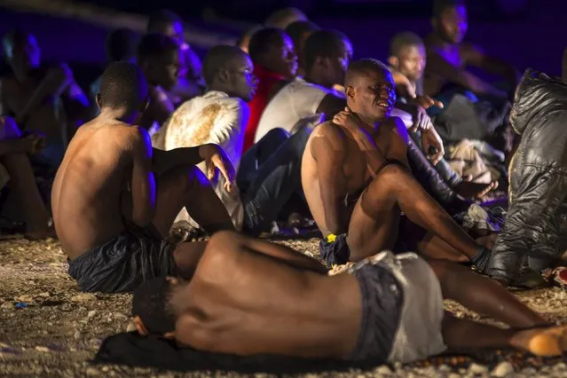 African migrants rest after arriving on a fishing boat at Las Carpinteras beach in the Canary Island of Gran Canaria, Spain, September 1, 2015. (Photo by Borja Suarez/Reuters)