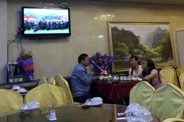 In this Monday, September 4, 2017 photo, Chinese people watch a TV showing a North Korean propaganda program as they dine at a North Korean restaurant in Dandong, northeastern China's Liaoning province. (Photo by Helene Franchineau/AP Photo)