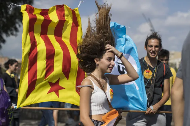 Students wave pro-independence flags while standing over an air vent as they demonstrate against the position of the Spanish government to ban the Self-determination referendum of Catalonia during a university students strike on September 28, 2017 in Barcelona, Spain. The Catalan goverment is keeping with its plan to hold a referendum, due to take place on October 1, which has been deemed illegal by the Spanish government in Madrid. (Photo by Dan Kitwood/Getty Images)
