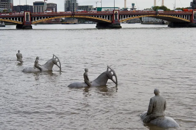 “The Rising Tide” by British underwater sculptor Jason deCaires Taylor is consumed by the waters of the River Thames, at Nine Elms on the South Bank, on September 4, 2015 in London, England. The installation is the artists's first commission in London and depicts four working horses and their riders. The statues will be concealed and revealed by the tide each day, highlighting the role the river has played in shaping London's history, and will run until September 30th. (Photo by Ben Pruchnie/Getty Images)