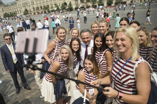 Russia's Sports Minister Vitaly Mutko with members of the Russia's National Olympic team members a one takes a take a selfie as they walk for a meeting with Russian President Vladimir Putin, in Moscow, Russia, Wednesday, July 27, 2016. At least 105 athletes from the 387-strong Russian Olympic team announced last week have been barred from the Rio Games in connection with the country's doping scandal. (Photo by Pavel Golovkin/AP Photo)