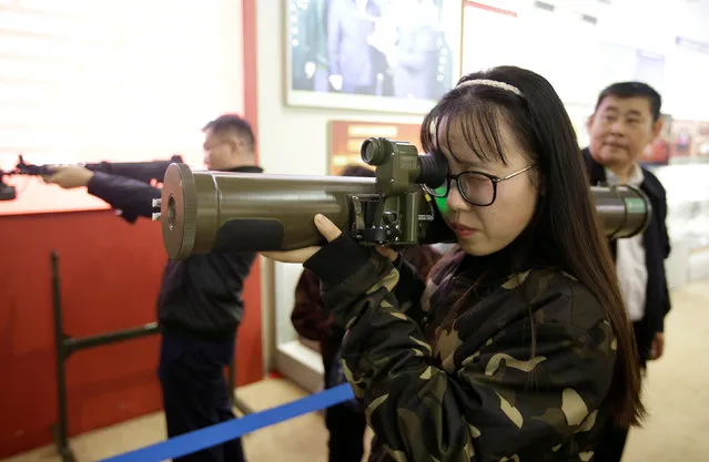 A visitor handles a model of a weapon at a military simulator area during an exhibition displaying China's achievements for the past five years, as a part of the celebrations of the upcoming 19th National Congress of the Communist Party of China (CPC) at Beijing Exhibition Centre in Beijing, China October 10, 2017. (Photo by Jason Lee/Reuters)
