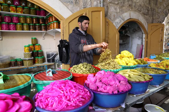 A shop vendor sells pickles in the old city of West bank town of Hebron, 29 April 2020. Muslims around the world celebrate the holy month of Ramadan, by praying during the night time and abstaining from eating, drinking, and sexual acts during the period between sunrise and sunset. Ramadan is the ninth month in the Islamic calendar and it is believed that the revelation of the first verse in Koran was during its last 10 nights. (Photo by Abed Al Hashlamoun/EPA/EFE)