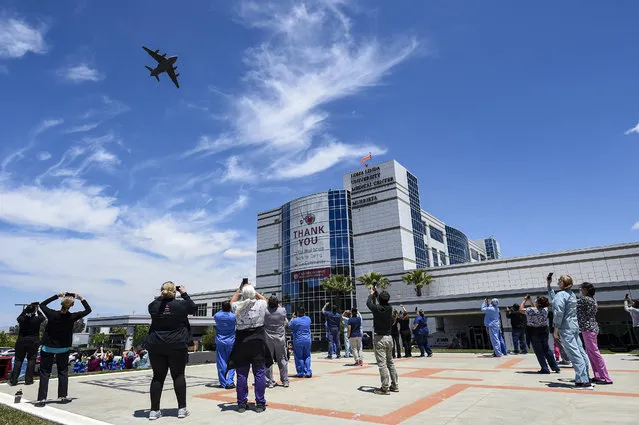 A United States Air Force C-17 Globemaster III of the 452nd Air Mobility Wing from March ARB completes a flyover of the Loma Linda University Medical Center to the excitement of the hospital staff on the ground in a salute to the frontline workers who are battling the Coronavirus (COVID-19) pandemic on May 14, 2020, in Murrieta, CA. The flyover route passed over 19 individual medical facilities in the region within approximately 90 minutes. (Photo by Chris Williams/Icon Sportswire)