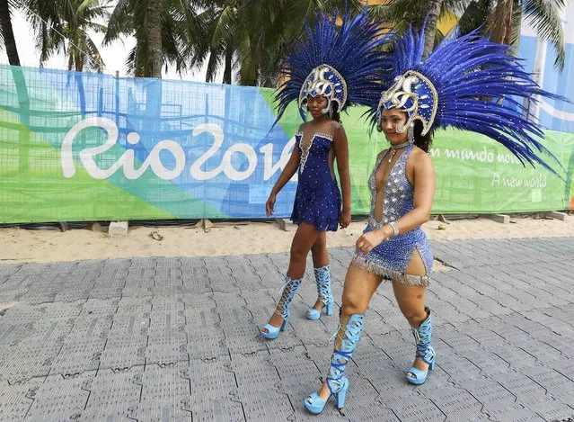 2016 Rio Olympics, Beach Volleyball, Women's Preliminary, Beach Volleyball Arena, Rio de Janeiro, Brazil on August 7, 2016. Dancers walk past the beach volleyball venue. (Photo by Lucy Nicholson/Reuters)