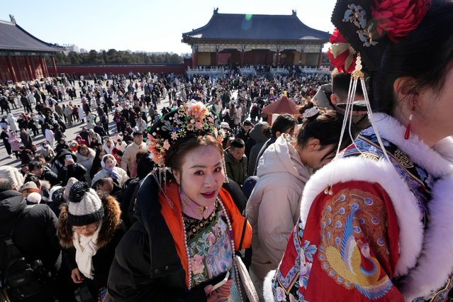 A woman in traditional dress walks with the crowd at the Temple of Heaven complex during a week-long Chinese New Year holiday in Beijing on Sunday, February 2, 2025. (Photo by Aaron Favila/AP Photo)