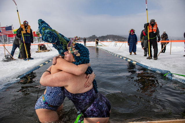 Swimmers embrace after finishing the 25 meter hat competition swim during the Memphremagog Winter Swimming Festival at lake Memphremagog in Newport, Vermont on February 21, 2025. (Photo by Joseph Prezioso/AFP Photo)