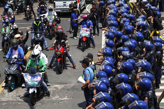 Police personnel standing guard (R) look on as supporters of former Philippine president Rodrigo Duterte continue their motorcade calling for the return of the former leader, in Manila, Philippines, 16 March 2025. Duterte, who is being held in Scheveningen prison in the Netherlands, is facing charges of crimes against humanity before the International Criminal Court (ICC) following investigations into a war on drugs campaign that resulted in thousands of alleged extrajudicial killings during his presidency. (Photo by Rolex Dela Pena/EPA)