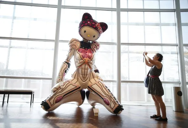 A woman photographs “Super Space Titan Kitty” by Colin Christian at the “Hello! Exploring the Supercute World of Hello Kitty” museum exhibit in honor of Hello Kitty's 40th anniversary, at the Japanese American National Museum in Los Angeles, California October 10, 2014. (Photo by Lucy Nicholson/Reuters)