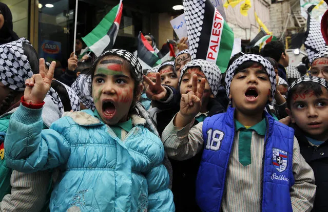 Children hold Palestinian flags as they flash victory signs during a sit-in in the Bourj al-Barajneh Palestinian refugee camp, in Beirut, Lebanon, Wednesday, December 6, 2017. (Photo by Bilal Hussein/AP Photo)