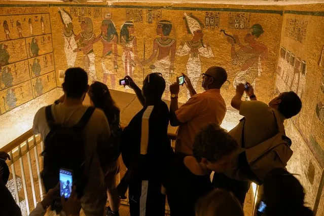 Tourists film inside the tomb of King Tutankhamun in the Valley of the Kings in Luxor, Egypt, Friday, November 4, 2022. Egypt celebrates the 100-year anniversary of the discovery of Tutankhamun's tomb on Nov. 4, 1922, by British archaeologist Howard Carter and his team. (Photo by Amr Nabil/AP Photo)
