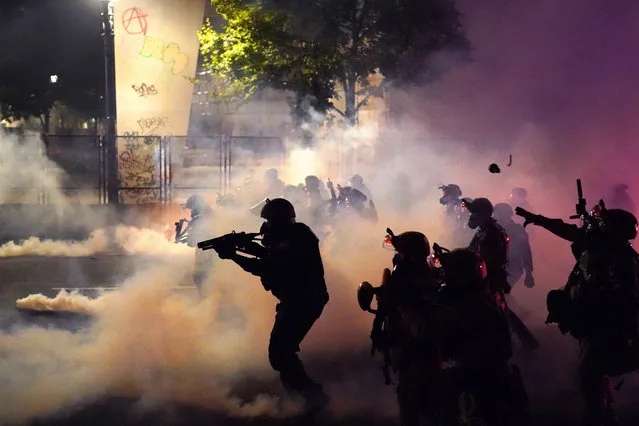 Federal officers deploy tear gas and less-lethal munitions while dispersing a crowd of about a thousand protesters in front of the Mark O. Hatfield U.S. Courthouse on Thursday, July 24, 2020 in Portland, Oregon. Protesters continued to clash with federal officers Friday morning as President Trump announced plans to deploy similar federal forces to other U.S. cities. (Photo by Nathan Howard/Getty Images)