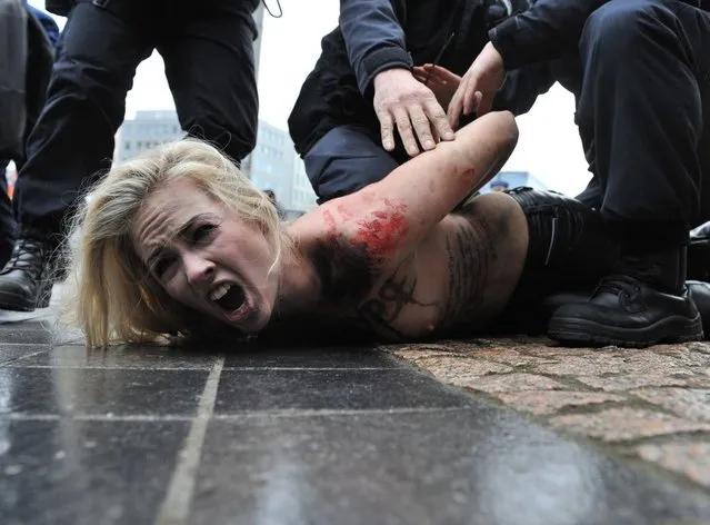 An activist of Ukraine's feminist movement Femen is taken away by the police as she demonstrates by the EU Council building where the EU-Russia summit is taking on December 21, 2012 in Brussels