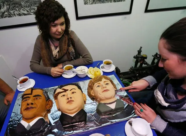 Participants drink tea and eat cakes made to look like U.S. president Barack Obama, North Korean leader Kim Jong Un and German Chancellor Angela Merkel during the art performance titled, “Sweet Sanctions. Let's eat each other only for fun” in Krasnoyarsk, Siberia, October 23, 2014. (Photo by Ilya Naymushin/Reuters)