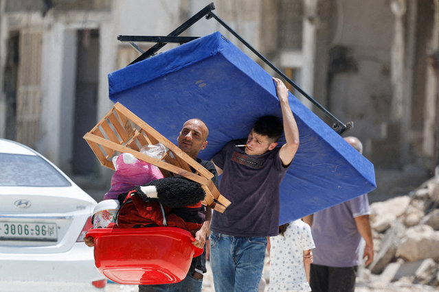 Palestinians carry their belongings after Israel's decision to demolish their homes in Nur Shams camp, in the Israeli-occupied West Bank on May 6, 2025. (Photo by Raneen Sawafta/Reuters)