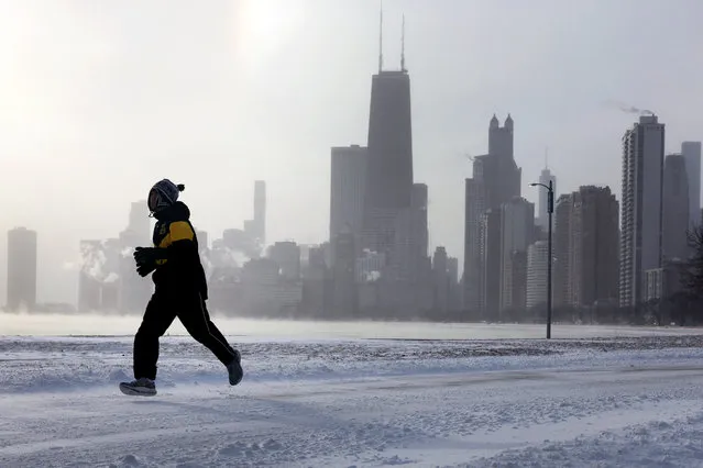 A jogger runs along Lake Michigan at sunrise as temperatures hover about -8 degrees on December 22, 2022 in Chicago, Illinois. Sub-zero temperatures are expected to grip the city for the next couple of days with wind chill temperature dipping as low as –40 degrees.   Scott Olson/Getty Images/AFP Photo)