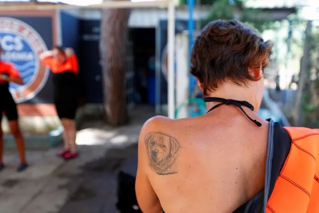 A tattoo in pictured on the shoulder of a member of an all-female group of canine rescuers from the Italian School of Rescue Dogs (La Scuola Italiana Cani Salvataggio) as she gets ready to attend a training session with her dog before patrolling the beach to ensure swimmers can enjoy their time at the sea in safety, in Riva dei Tarquini, near Rome, Italy, August 25, 2020. (Photo by Guglielmo Mangiapane/Reuters)
