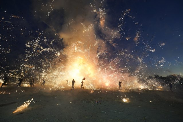 Residents attend the nighttime lighting of giant paper-mache “toritos” or bulls stuffed with fireworks during the annual festival honoring Saint John of God, in Tultepec, Mexico, Friday, March 8, 2024. The celebration, now its 35th year, pays homage to the patron saint of the poor and sick, St. John of God, who the fireworks' producers view as a protective figure. (Photo by Marco Ugarte/AP Photo)