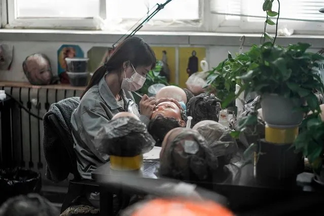 This photo taken on February 1, 2018 shows a worker painting the face of a silicone doll at a factory of EXDOLL, a firm based in the northeastern Chinese port city of Dalian. (Photo by Fred Dufour/AFP Photo)