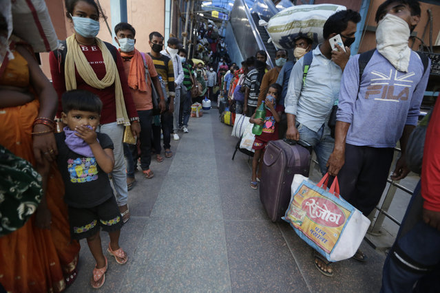 Indian passengers queue up to test for COVID-19 at a facility erected at a railway station to screen people coming from outside the city, in Ahmedabad, India, Friday, September 18, 2020. India's coronavirus cases jumped by another 96,424 in the past 24 hours, showing little sign of leveling. India is expected to have the highest number of confirmed cases within weeks, surpassing the United States, where more than 6.67 million people have been infected. (Photo by Ajit Solanki/AP Photo)