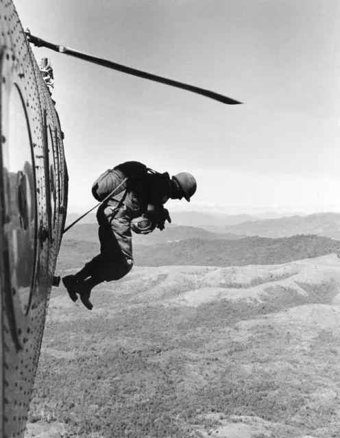 American Special Forces Troops in South Vietnam, working with Vietnamese Rangers, are frequently called upon to parachute into the almost inaccessible central highlands region considered a Communist guerrilla stronghold, to make intelligence patrols. These groups go through frequent training sessions to maintain their efficiency in jumping. One Special Forces man jumps from an H-21 helicopter in the area near Tacanh, north of Kontum, January 4, 1963. (Photo by AP Photo/Faas)