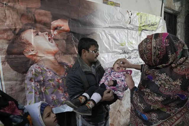 A health worker administers a polio vaccine to a child in Lahore, Pakistan, Monday, January 16, 2023. Pakistan is launching its first anti-polio campaign of the year, targeting more than 44 million children under the age of five. It is one of two countries in the world where polio continues to threaten the health and well-being of children. (Photo by K.M. Chaudary/AP Photo)