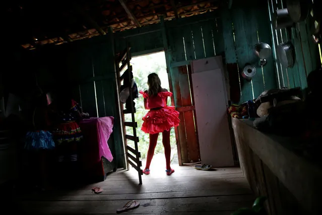 A member of the “Bloco Real Folia” group is seen inside her house during Carnival of the Waters, where costumed and colorful boats navigate the river Jaituba, around the islands near the city of Cameta, Brazil on February 8, 2018. (Photo by Ueslei Marcelino/Reuters)