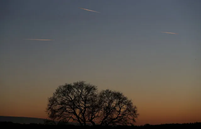 Passenger planes leave behind contrails as they fly in the skies over London Luton Airport, Luton, Britain, January 7, 2018. (Photo by Peter Cziborra/Reuters)